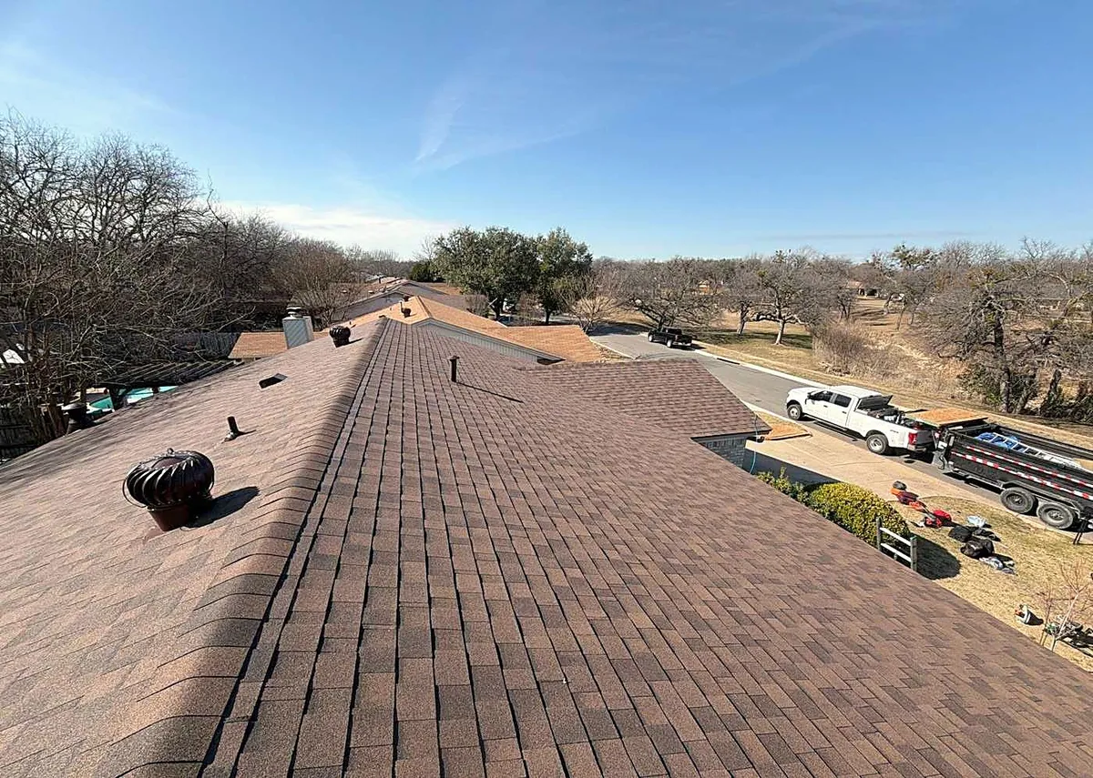 Looking down the ridge of a long new shingle roof