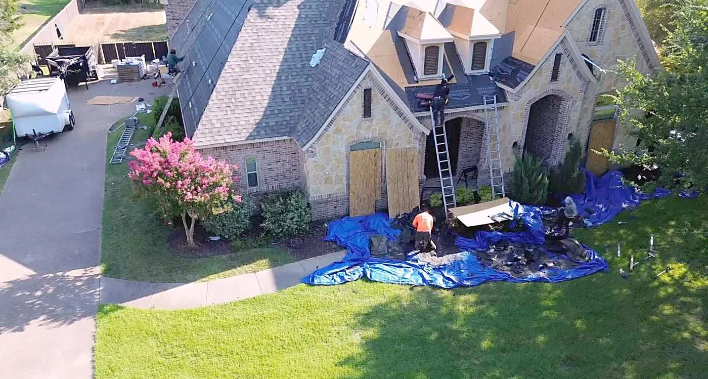 The Hul-Ster crew replacing a roof, with tarps laid out below to catch debris