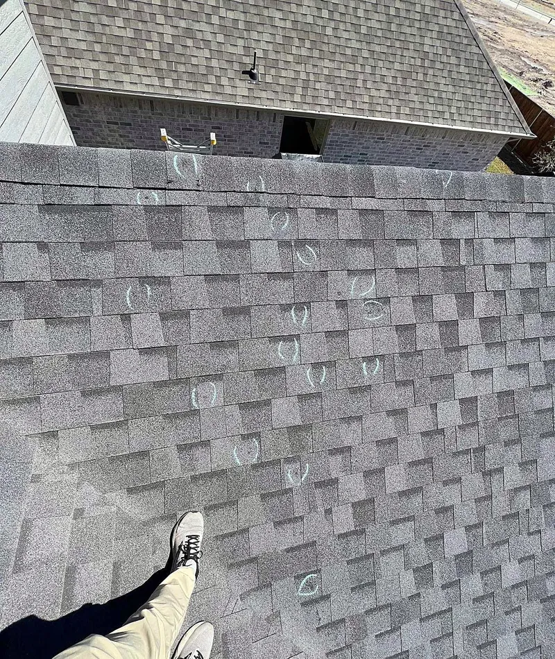 Shingles marked in chalk during a roof inspection